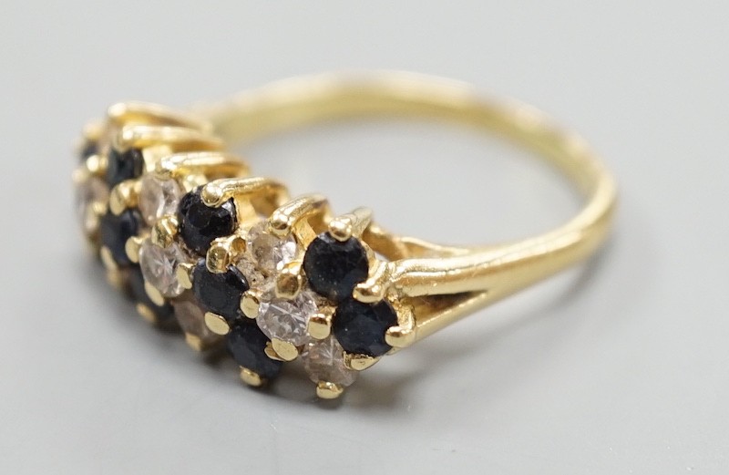 A modern 18ct, sapphire and diamond cluster set seven row half hoop ring, size P, gross weight 5.4 grams.